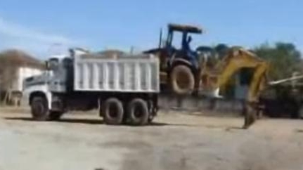 Un şofer priceput urcă un excavator, fără niciun ajutor, într-un camion