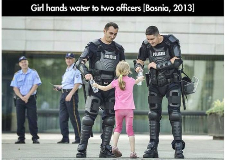O fetiţă le dăruieşte poliţiştilor câte o sticlă de apă, Bosnia, 2013