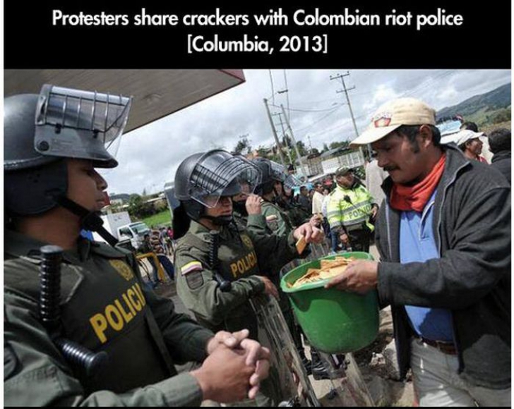 Un manifestant le împarte biscuiţi poliţiştilor columbieni
