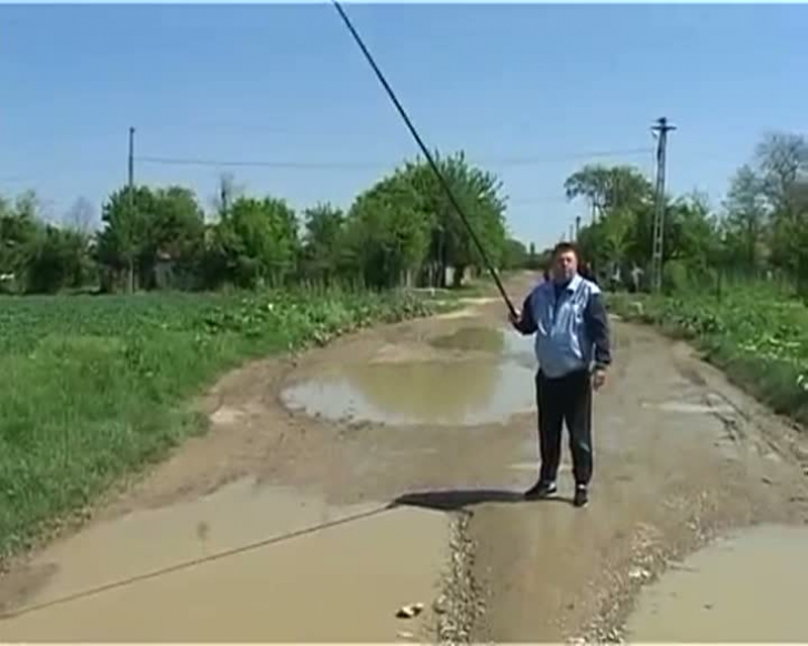 Pescuiesc în gropile de pe drum