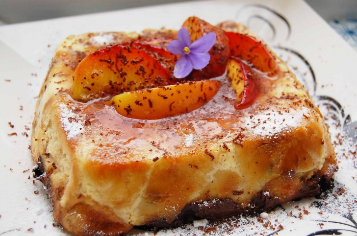 Budincă de croissante cu piersici caramelizate şi ciocolată neagră