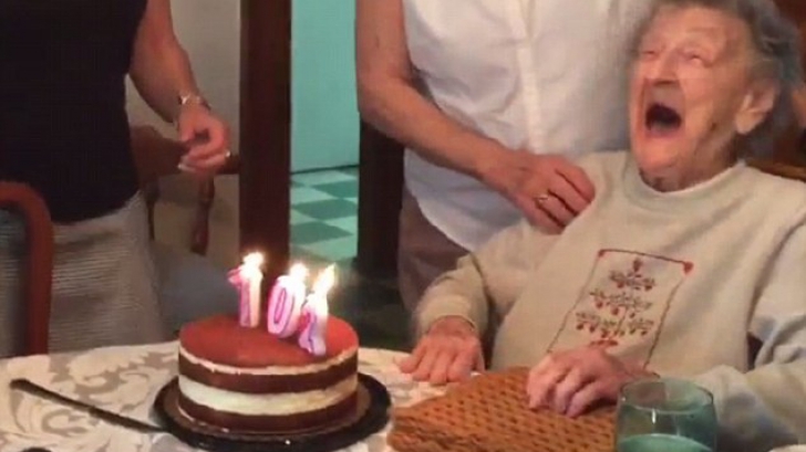 O bătrânică de 102 suflă în lumânările de pe tort