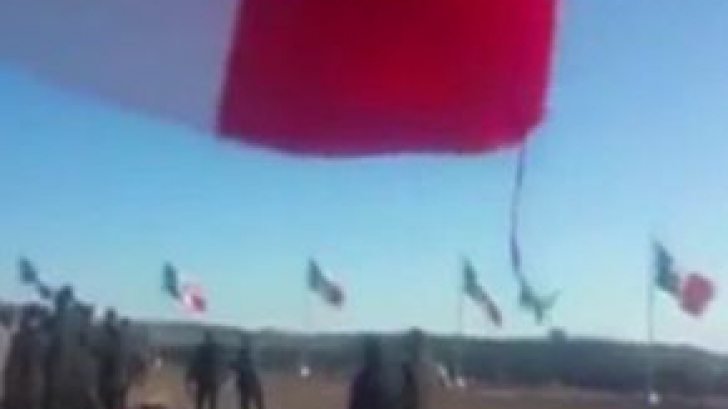 Un soldat mexican care ridica un steag a fost luat pe sus de o rafală de vânt