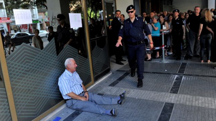 Tragedia greacă în imagini. Fotografia neputinței. Un bătrân plânge, deznădajduit, în fața băncilor 