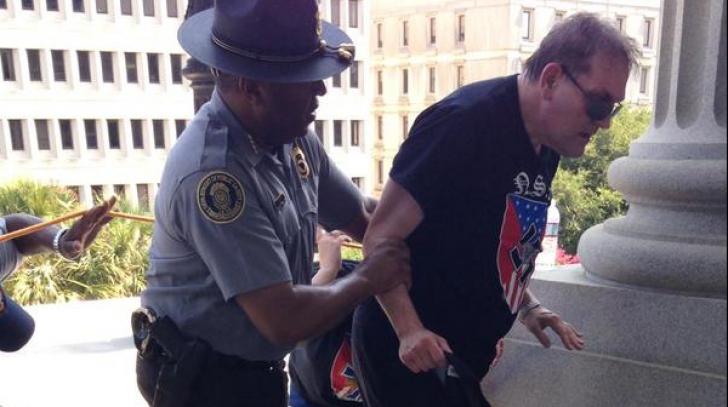 Un poliţist negru sare în ajutorul unui membru al Ku Klux Klan-ului, în statul Carolina de Sud