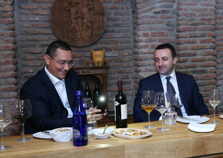 Imagini rare. Victor Ponta, într-o cramă, fotografiind sticle de vin alături de premierul Georgiei