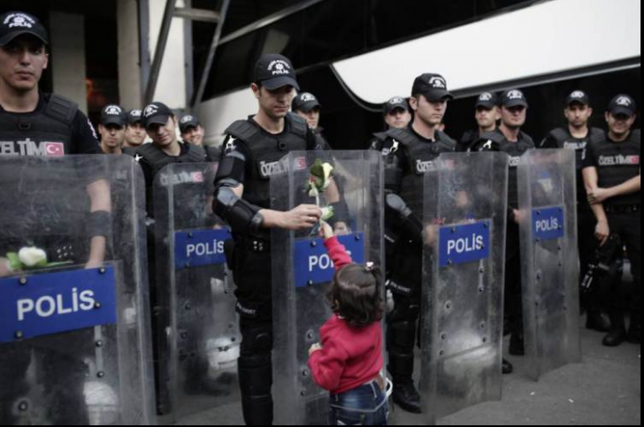 Imaginea zilei vine din Turcia: O fetiță din Siria oferă o floare cordonului de polițiști