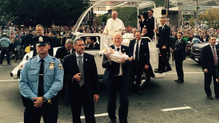 Un bebeluș îmbrăcat în haine papale l-a făcut să râdă pe Papa Francisc. Este adorabil!
