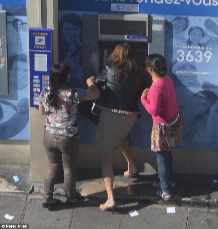 Fotografii şocante. Femeie jefuită în timp ce scoate bani de la bancomat, în plină zi