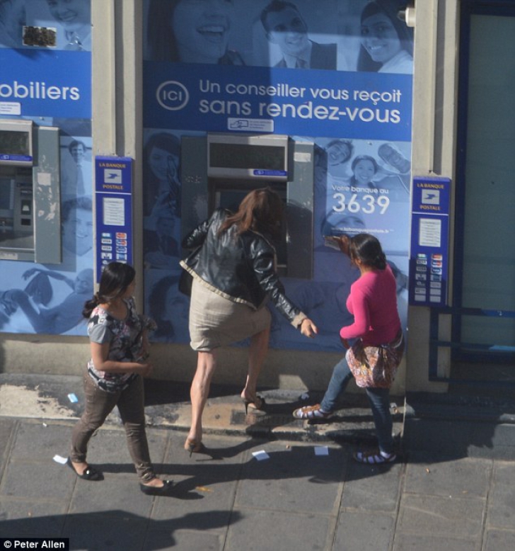 Fotografii şocante. Femeie jefuită în timp ce scoate bani de la bancomat, în plină zi