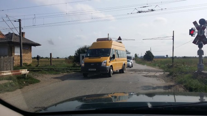 Cum a fost surprins şoferul unui autobuz şcolar, în Timiş: a trecut calea ferată pe roşu şi...