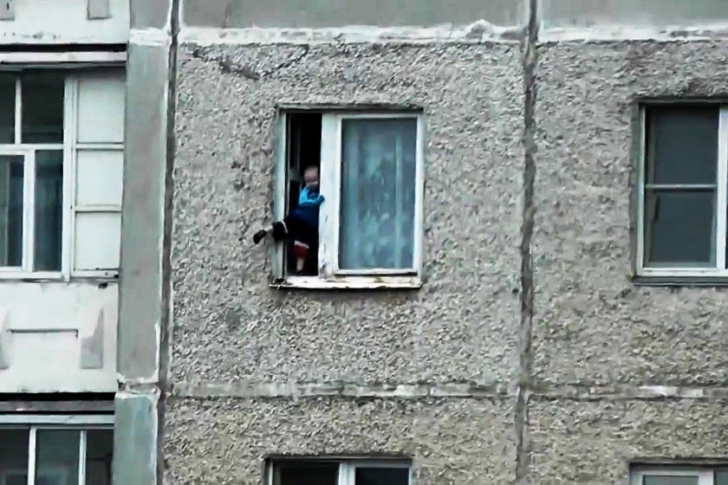 VIDEO ŞOCANT. La un pas de moarte. Un copil se joacă pe pervazul geamului, în picioare, la etajul 8