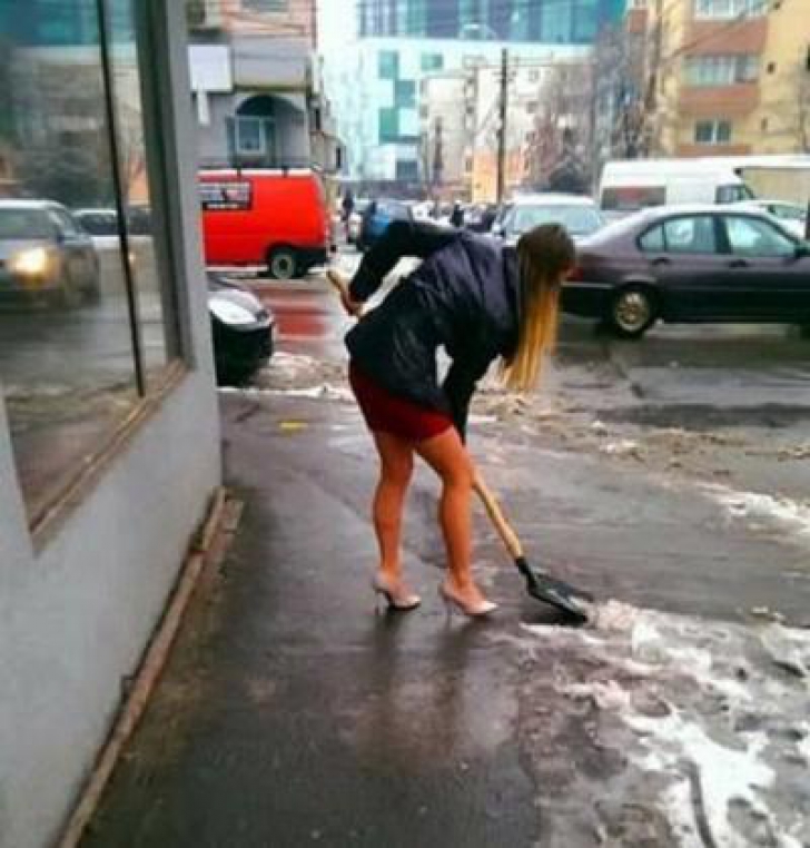 Imaginea zilei. Cum a curăţat o tânără gheaţa şi zăpada de pe trotuar, la Cluj