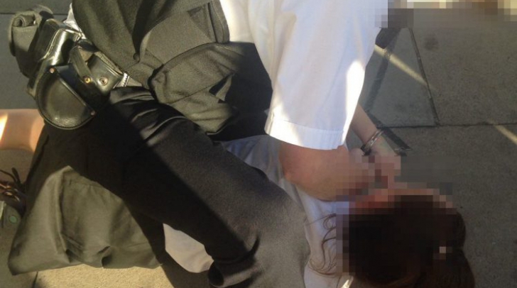 Imagini şocante! O adolescentă este târâtă pe asfalt de un poliţist în timp ce o arestează 