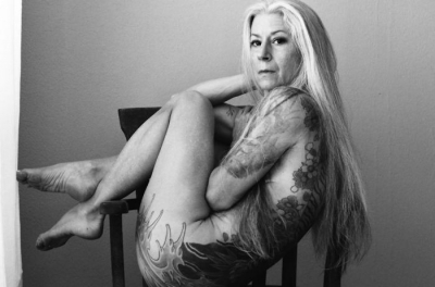 A pozat nud la 56 de ani. Corpul ei acoperit de tatuaje arată demenţial! 