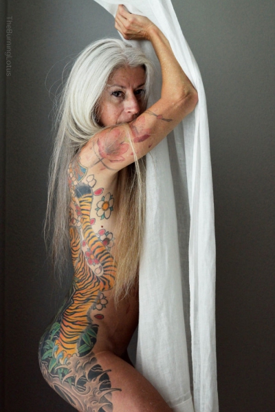 A pozat nud la 56 de ani. Corpul ei acoperit de tatuaje arată demenţial! 