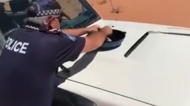 Gestul uimitor al unui poliţist: şi-a gătit prânzul pe capota maşinii de serviciu