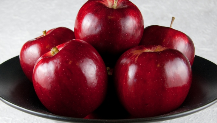 A cumpărat un kilogram de mere roşii, dar unul era special! Ce a apărut pe coaja fructului
