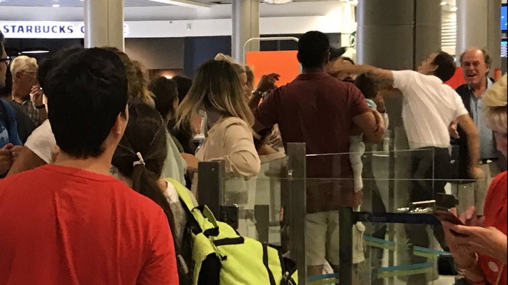 Imagine şocantă: un bărbat care îşi ţine bebeluşul în braţe, lovit de un angajat al aeroportului 