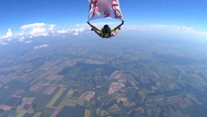 Mesajul anti PSD, în aer! Un paraşutist a sărit de la de 4.000 metri cu un banner M*** PSD 