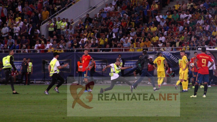 Momentul in care un steward cade incercand sa "agate" un fan intrat pe teren la Romania - Spania. Foto: Cristian Otopeanu