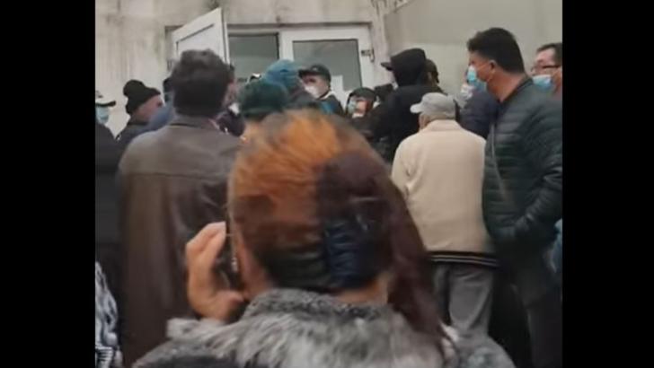 VIDEO - Imagini revoltătoare - Îmbrânceli între oamenii care așteaptă la coadă la spital. Aglomerație, așteptare în ploaie