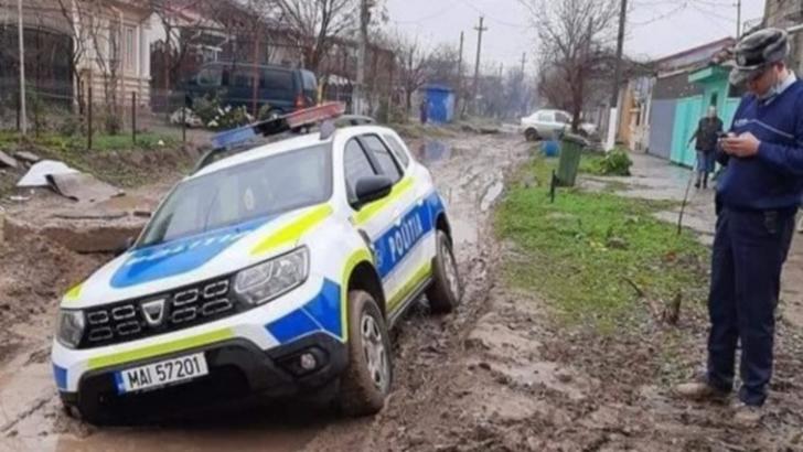 Mașină a poliției rămasă împotmolită în noroi pe o stradă din Brăila