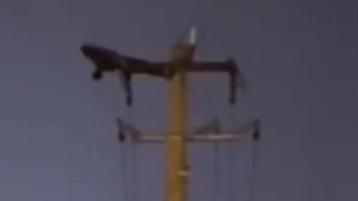 Un chinez face abdomene la înălțime, pe un stâlp de electricitate Foto: Captură video