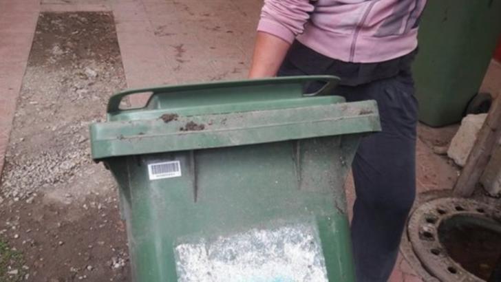 O femeie a fost surprinsă în timp ce transporta cadavrul unui bărbat într-un tomberon
