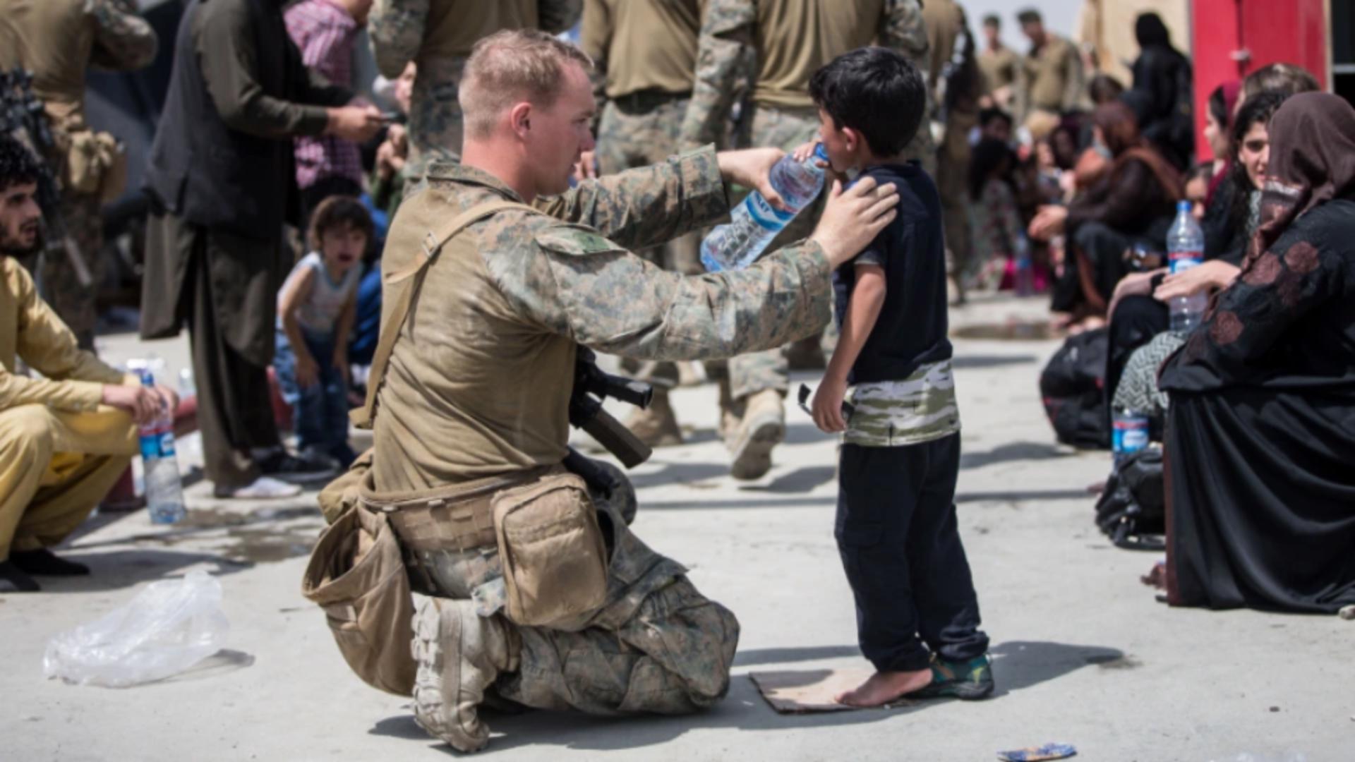 Soldat americani leagănă bebeluș afgan 
