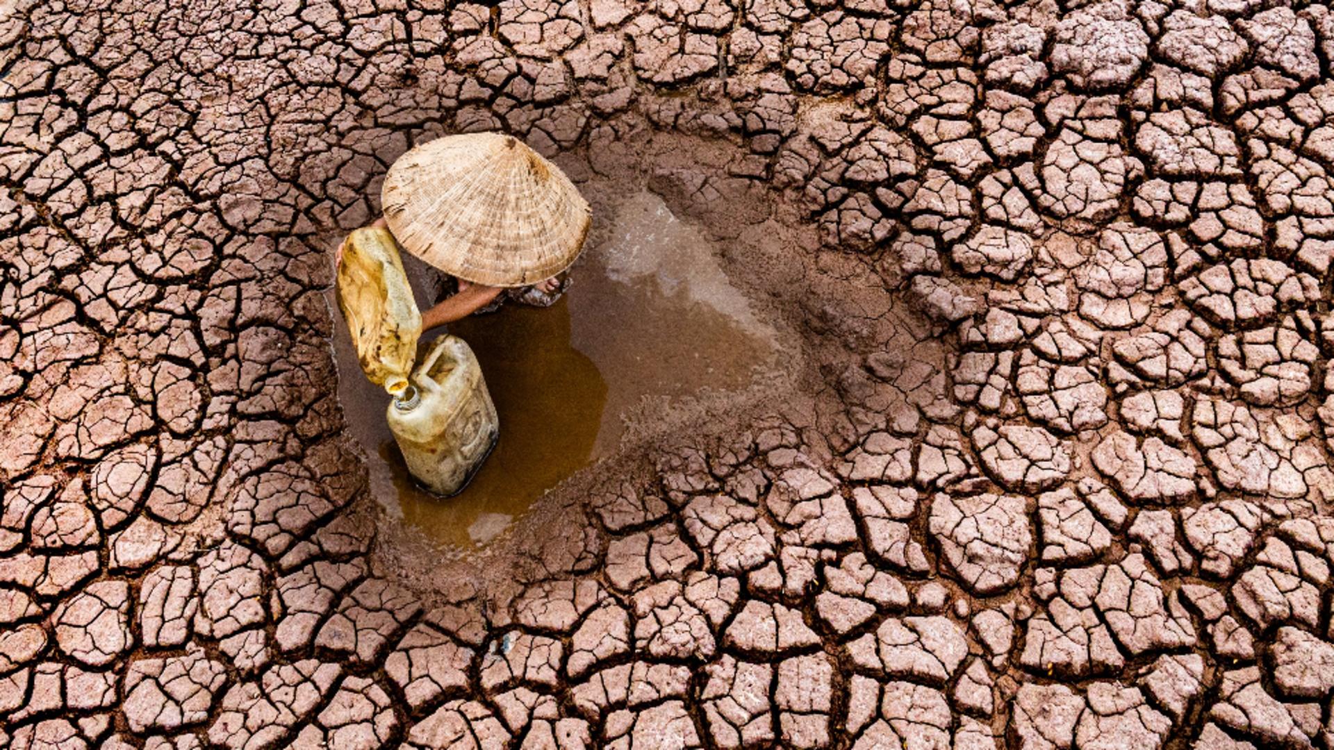 Un băiețel fotografiat adunând ultimele picături de apă. Sursa foto: Profi Media