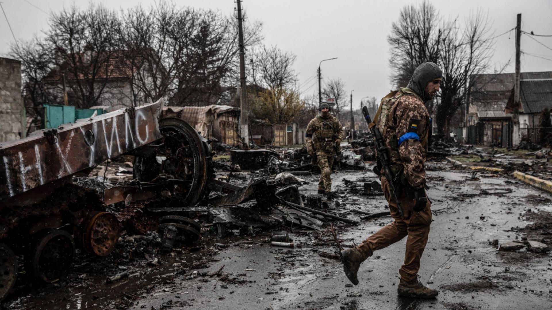 Soldați ucraineni printre rămășițele atacului din Bucea. Foto/Profimedia