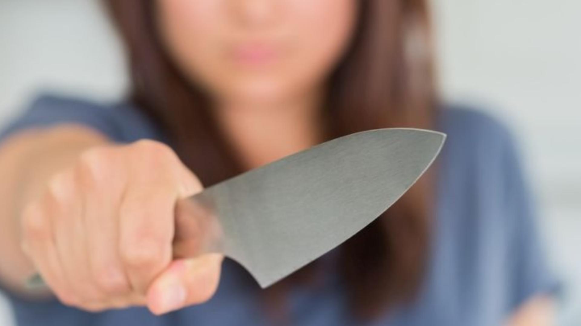 Femeie cu cuțit - imagine cu notă sugestivă