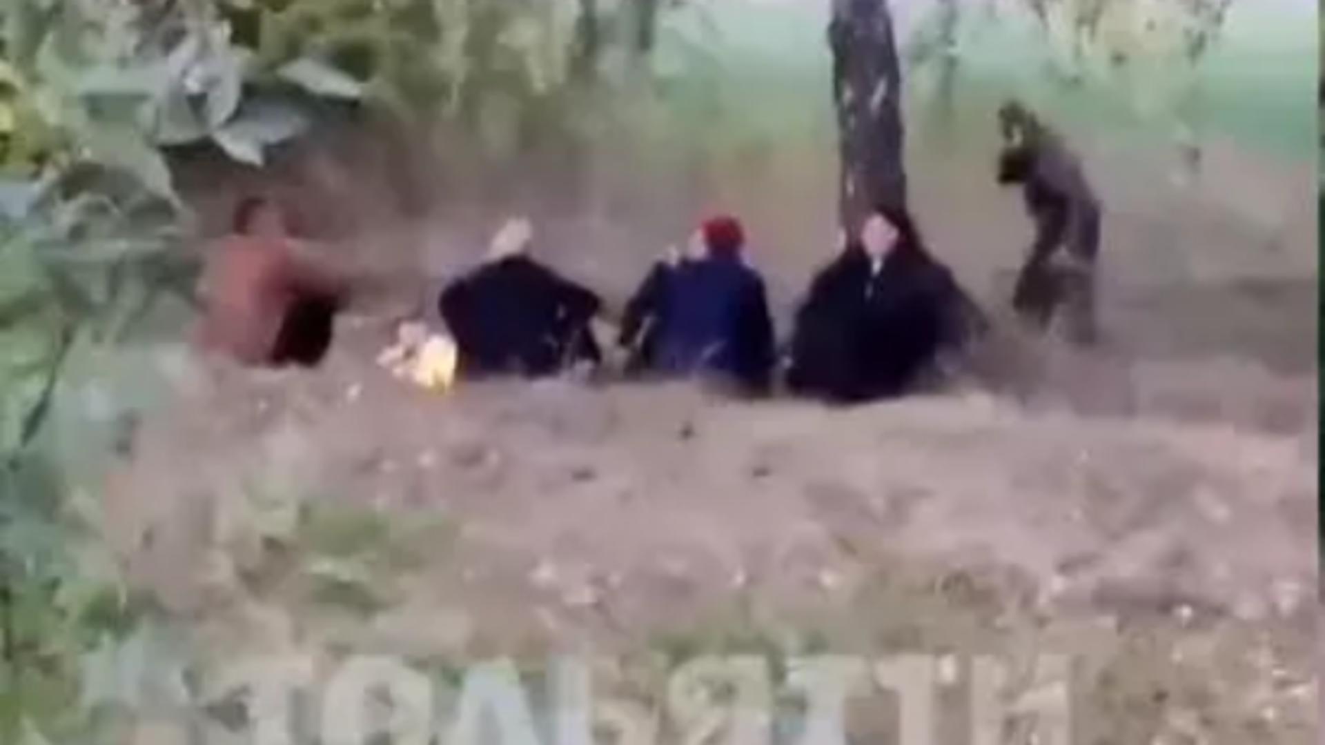 Recruți ruși se încălzesc în jurul focului/Captură video