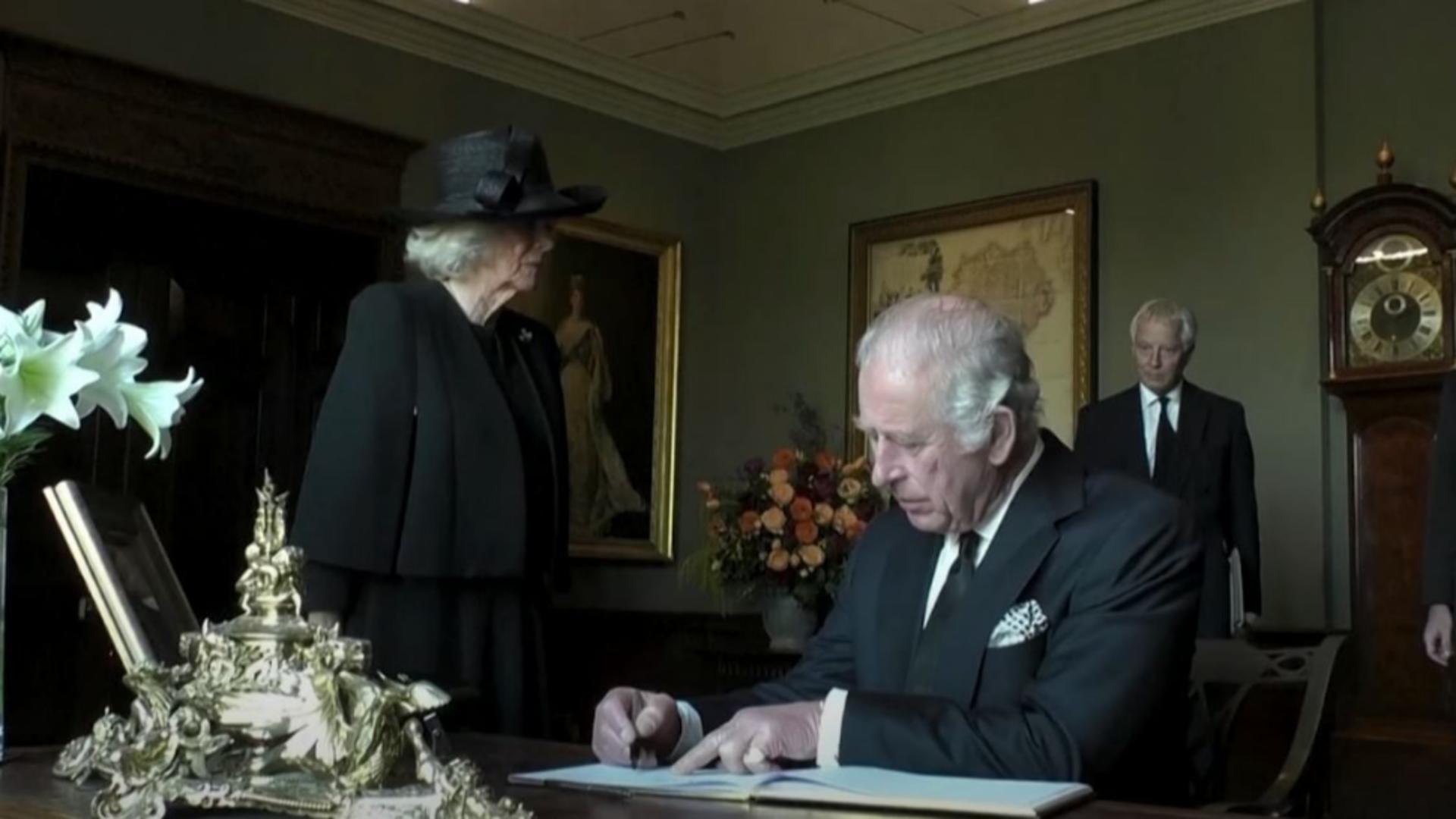 Regele Charles în timp ce semnează în cartea de oaspeți a Castelului Hillsborough. Foto/Captură video