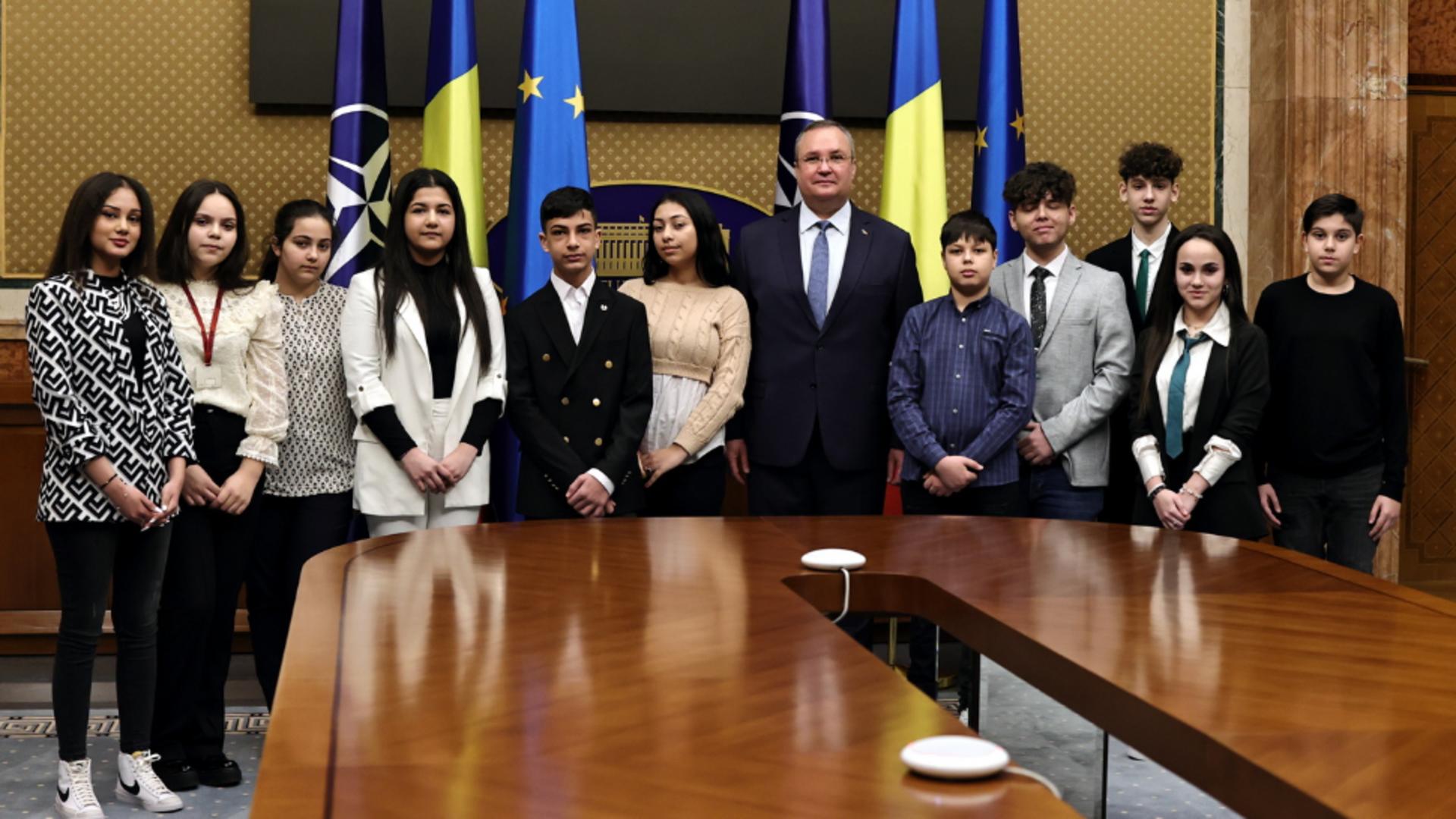Nicolae Ciucă împreună cu un grup de elevi de etnie romă/ Facebook Guvern