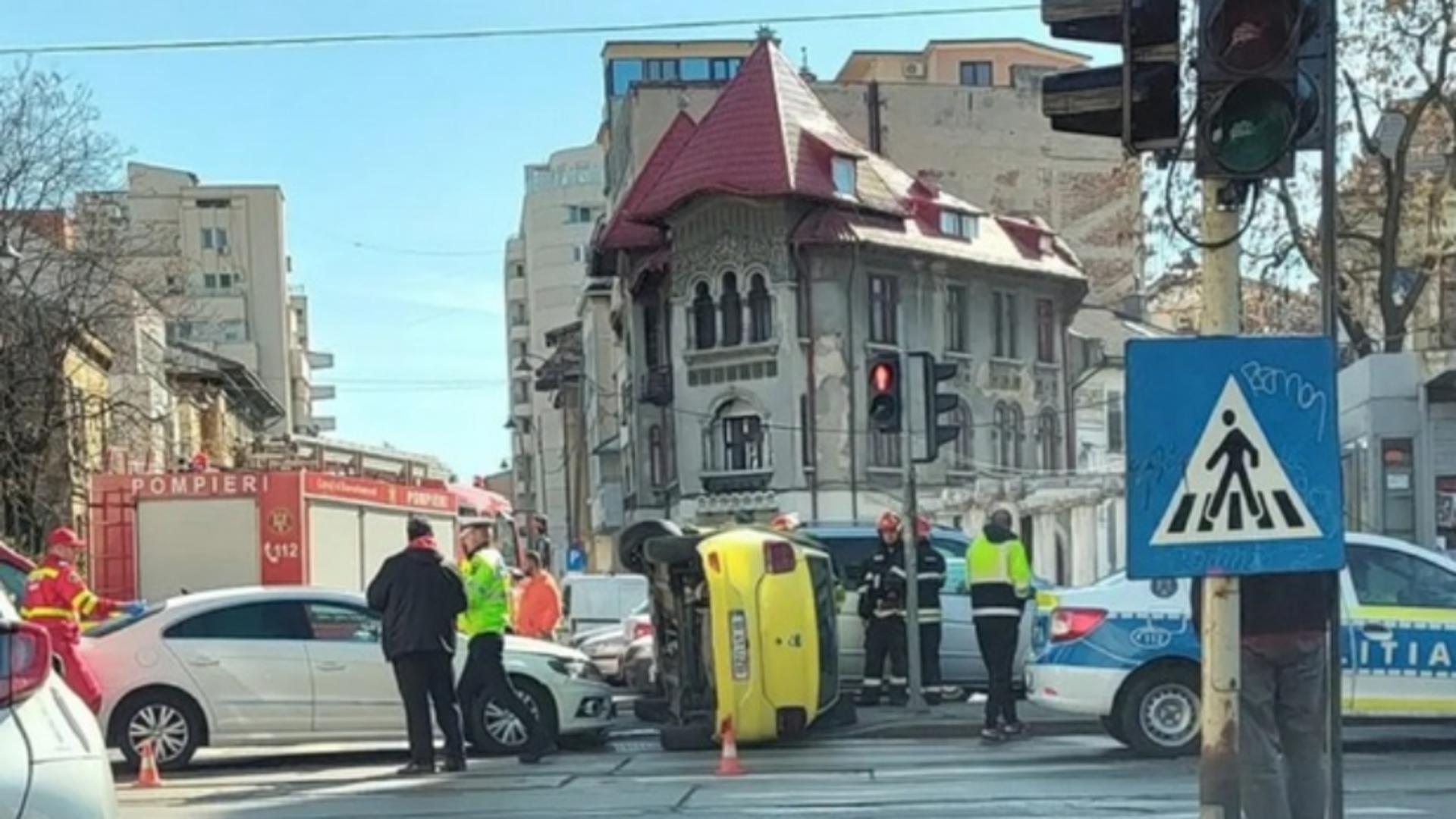 Taxi răsturnat pe linia de tramvai, în centrul Capitalei - clientul a fost rănit