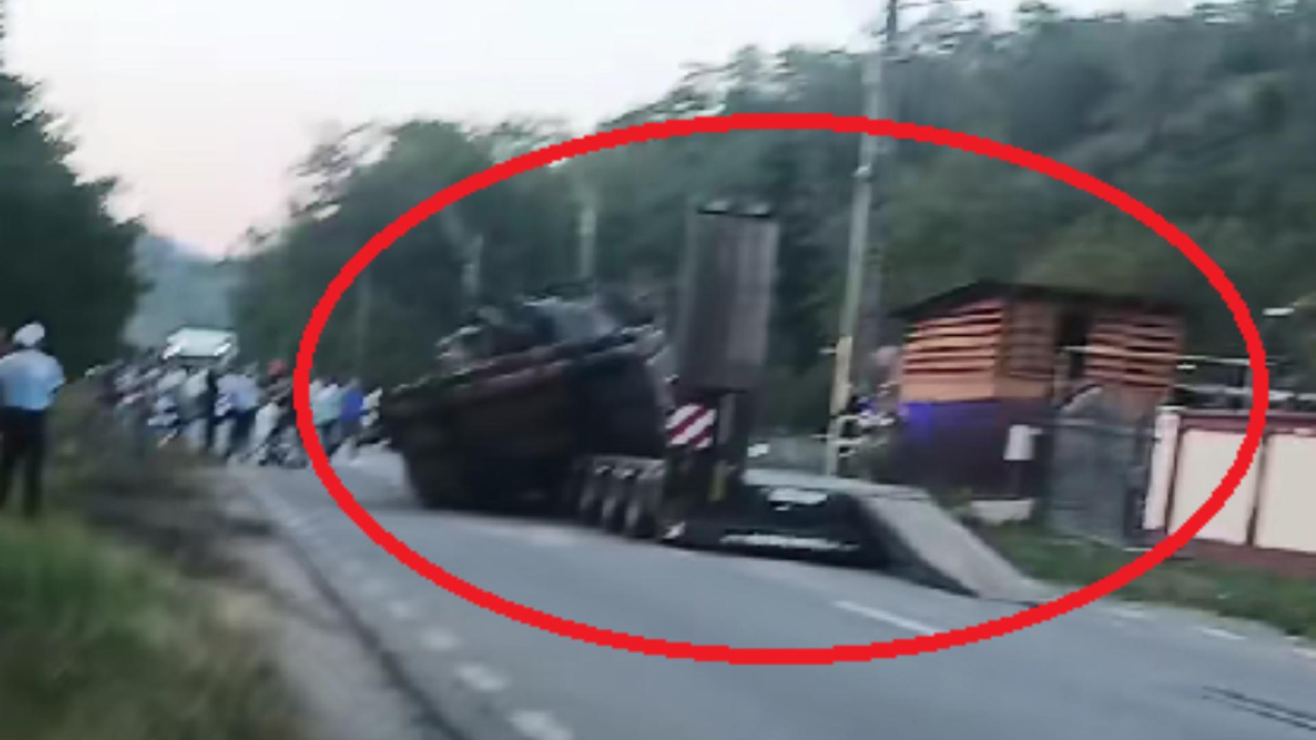 Un tanc a căzut de pe platforma care îl transporta! Șoferul a evitat “la mustață” un pieton care traversa neregulamentar
