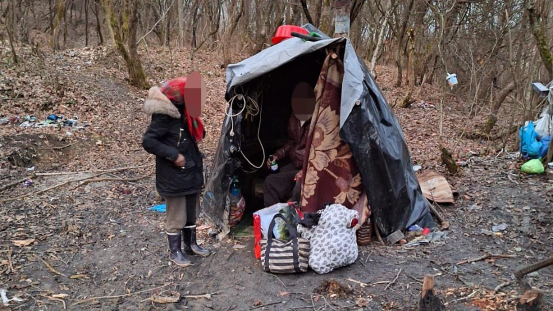 O familie cu doi copii, găsită în pădure locuind într-un cort din crengi acoperit cu pături și celofan. Micuții, grav bolnavi