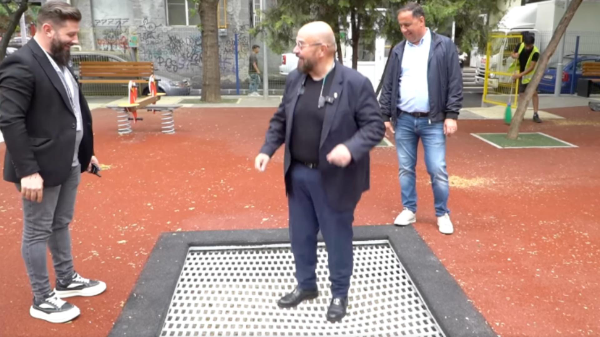 Cristian Popescu Piedone sare pe o trambulina in parcul de copii