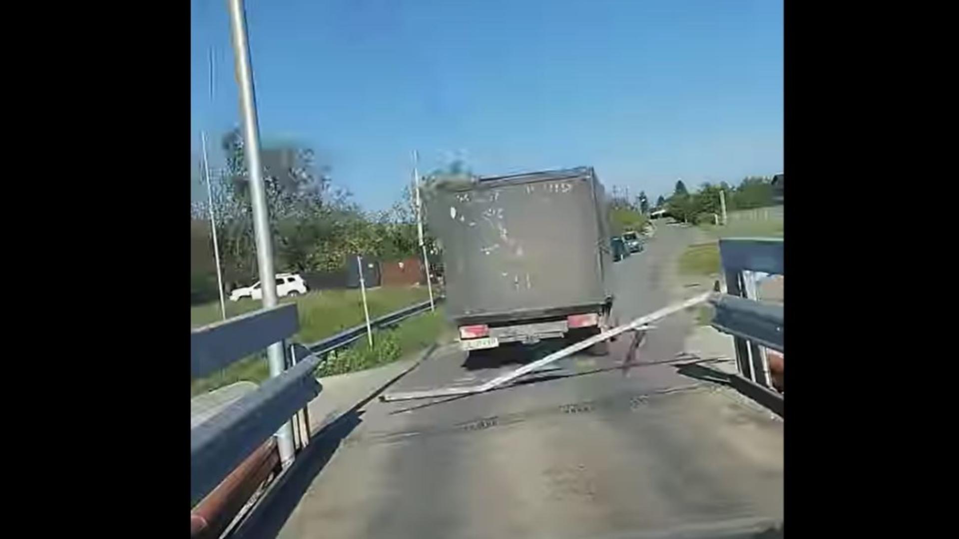 Momentul în care șoferul dărâmă poarta de gabarit a podului. Foto/Captură video
