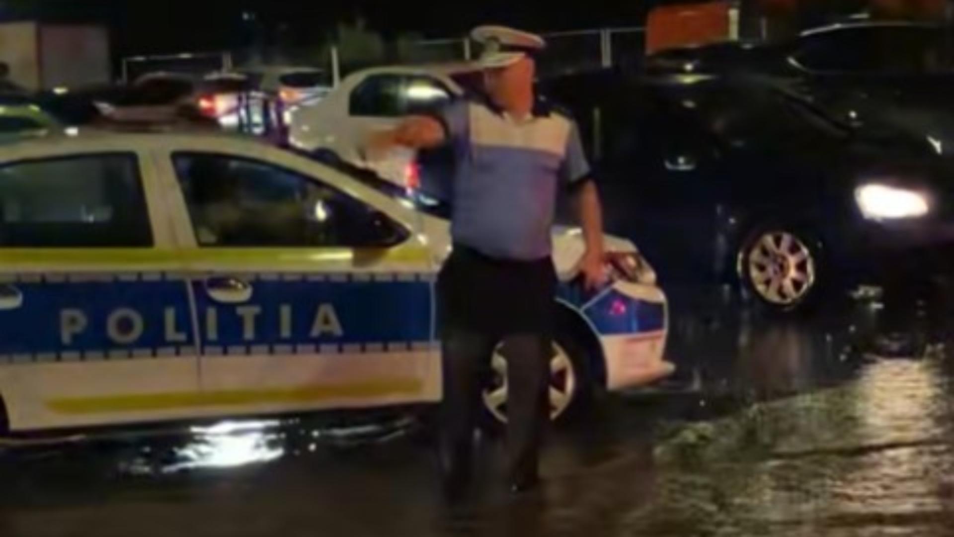 Eroul în uniformă albastră care a dirijat traficul în timpul furtunii. A stat cu apa până la genunchi în mijlocul intersecției - VIDEO