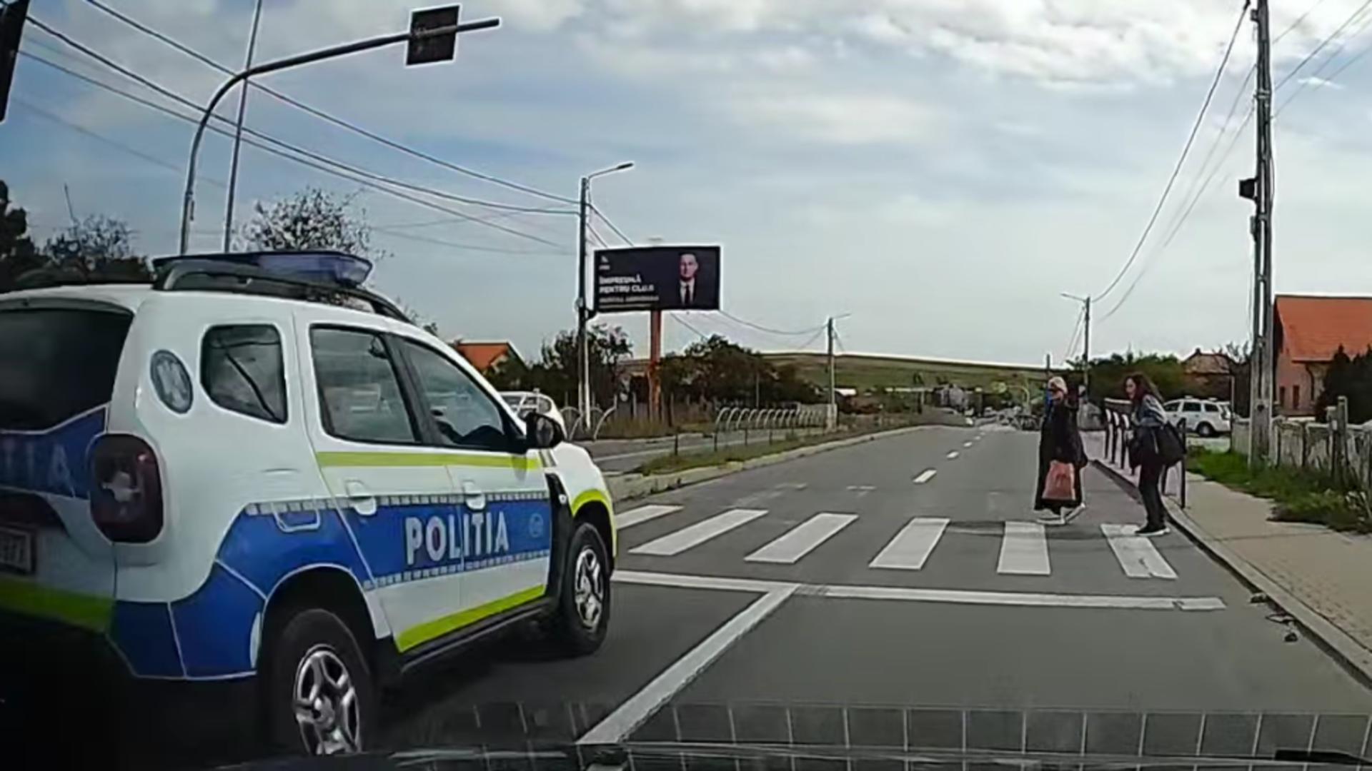 Doi pietoni, la un pas să fie spulberați de o mașină de poliție pe o trecere de pietoni/ Captură video Facebook Info Trafic Cluj-Napoca