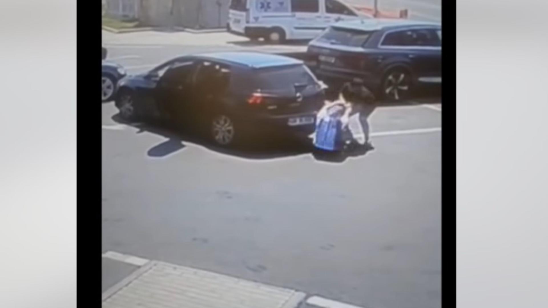 Momentul în care femeia este târâtă pe asfalt ca să fie urcată în mașina agresorilor. Foto/Captură video