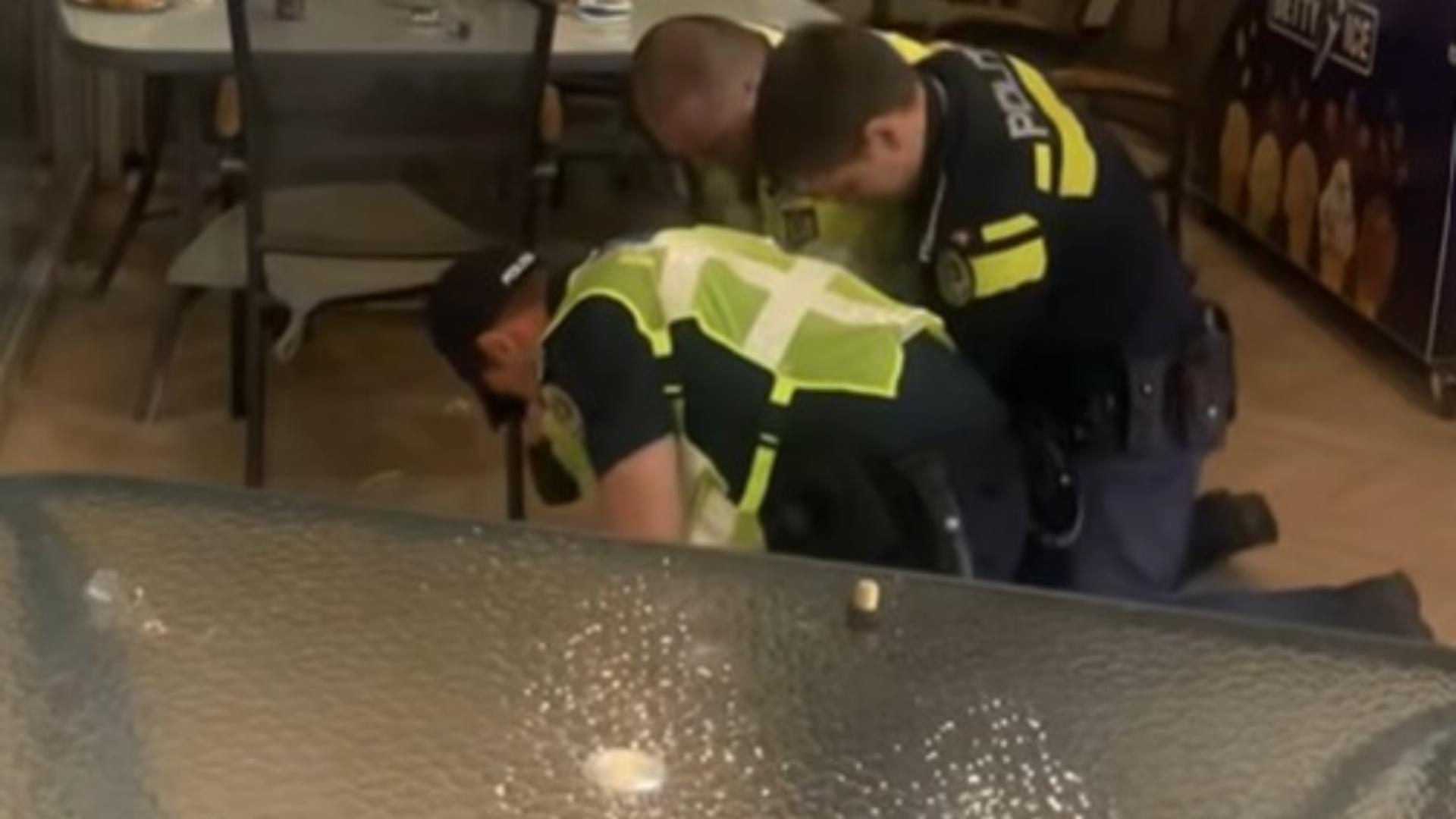 Bărbații s-au luptat din greu cu polițiștii, care au fost nevoiți să-i încătușeze. Foto/Captură video