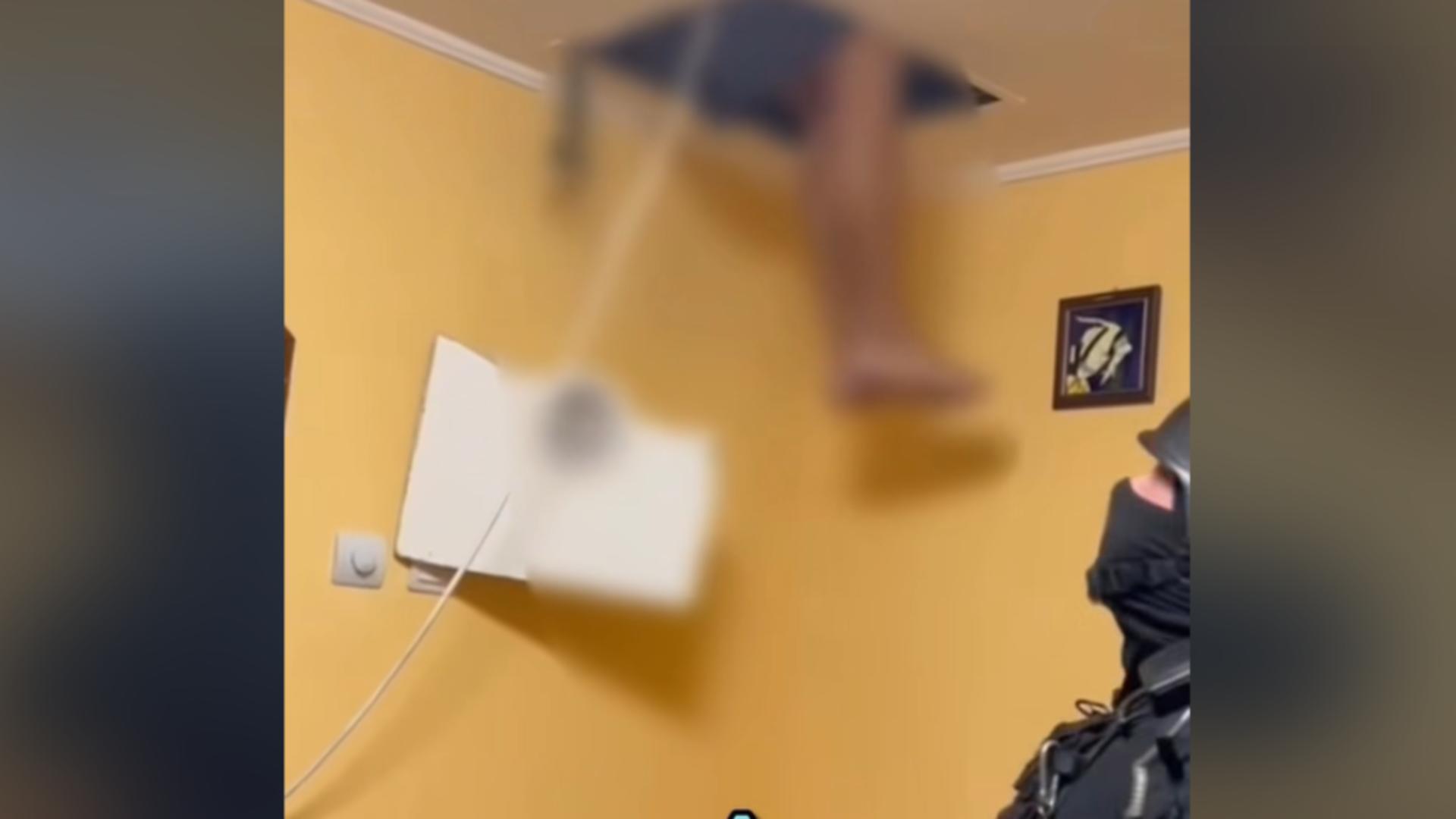 Momentul în care un infractor coboară din tavanul fals unde s-a ascuns de frica mascaților