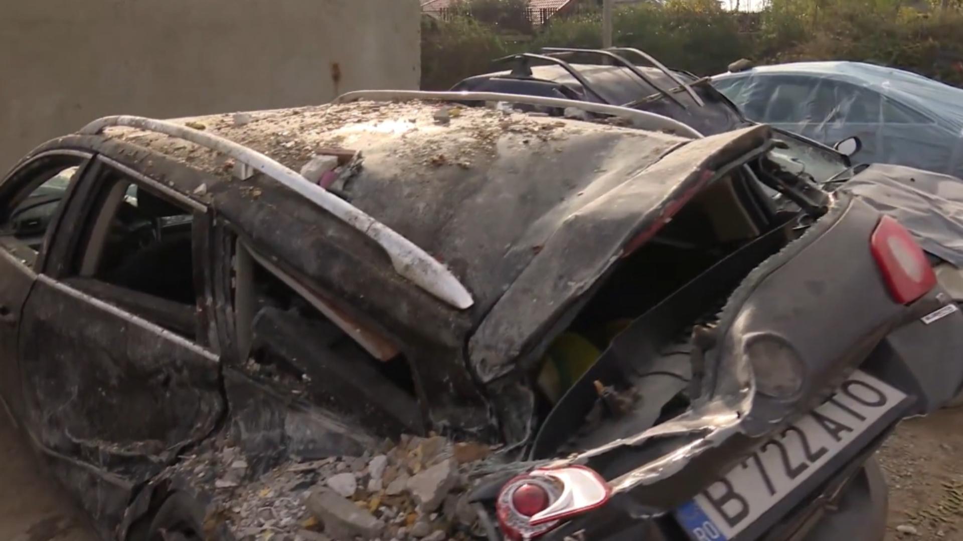 Oamenii privesc neputincioși spre ruinele locuințelor și spre mașinile avariate. Foto/Realitatea