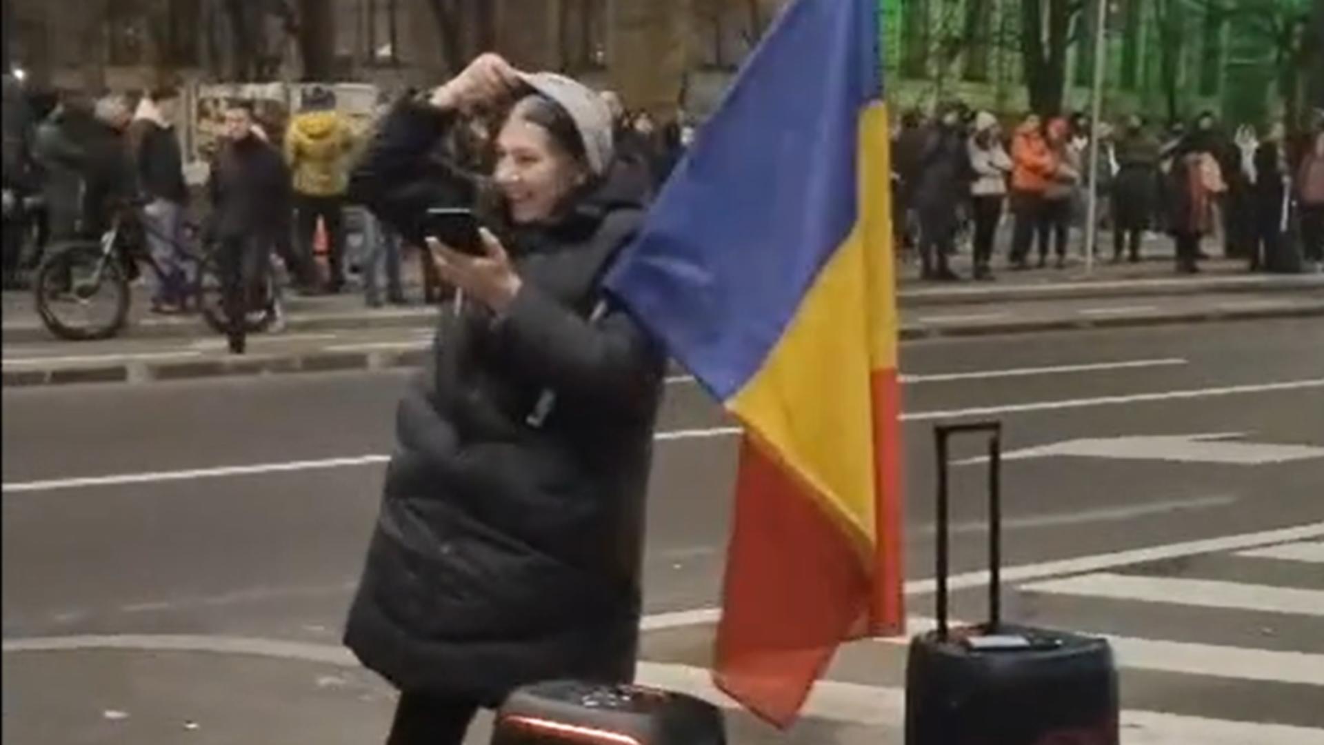 Incident la mitingul din Piața Victoriei. Ce a pățit o protestatară care a venit cu drapelul României și a pus muzică patriotică - Video