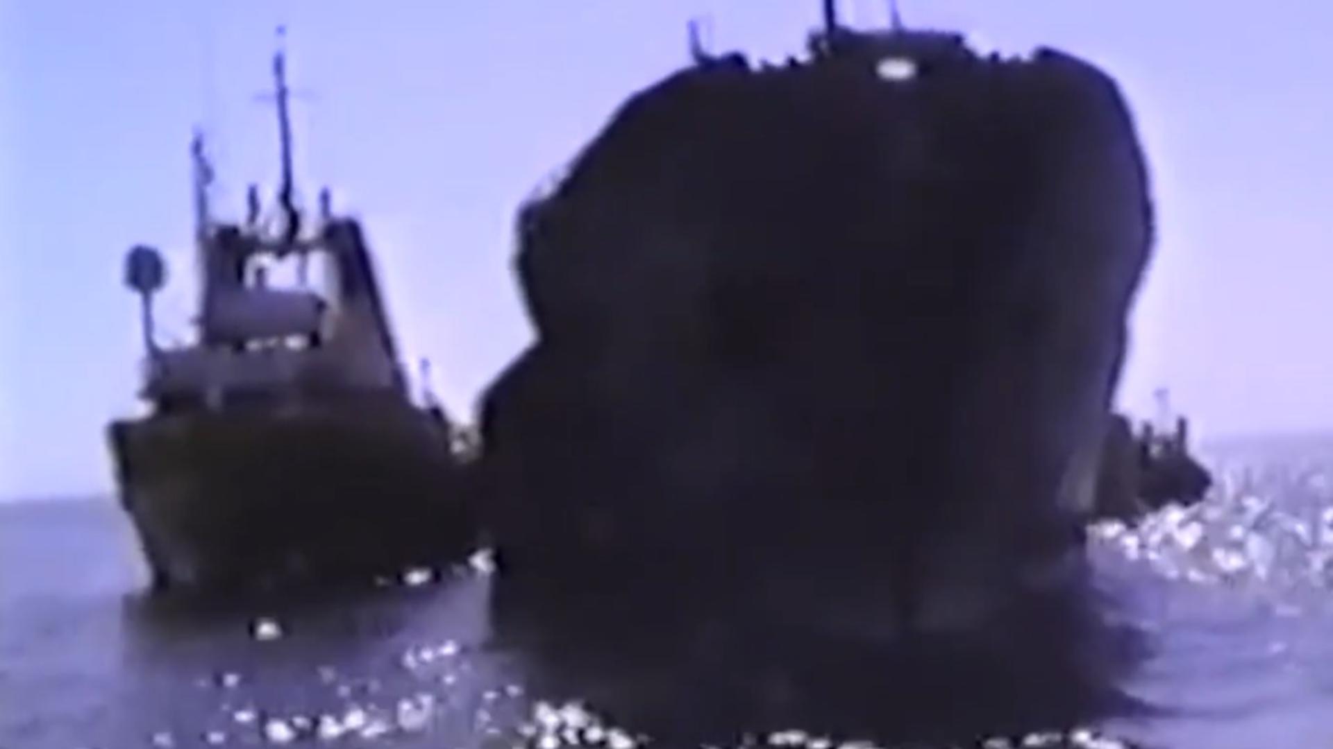 Nava Fundulea asistată de un remorcher în largul mării. 